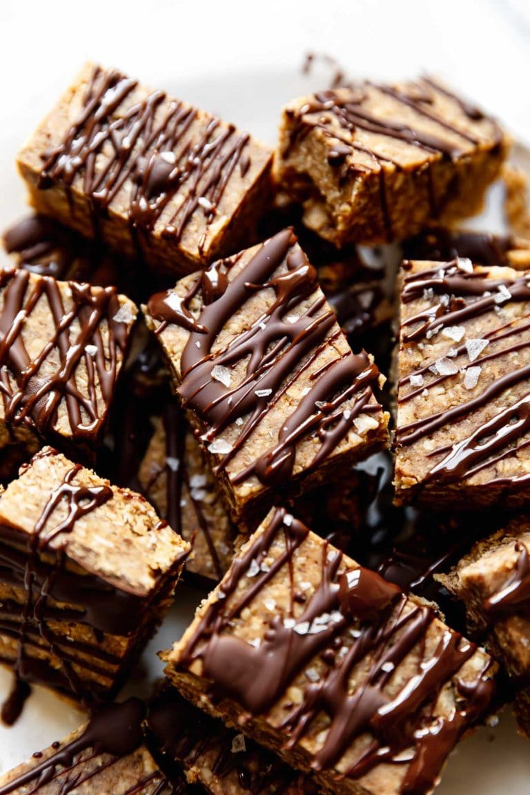 A batch of mini peanut butter protein bars drizzled with chocolate and topped with flakey sea salt. 