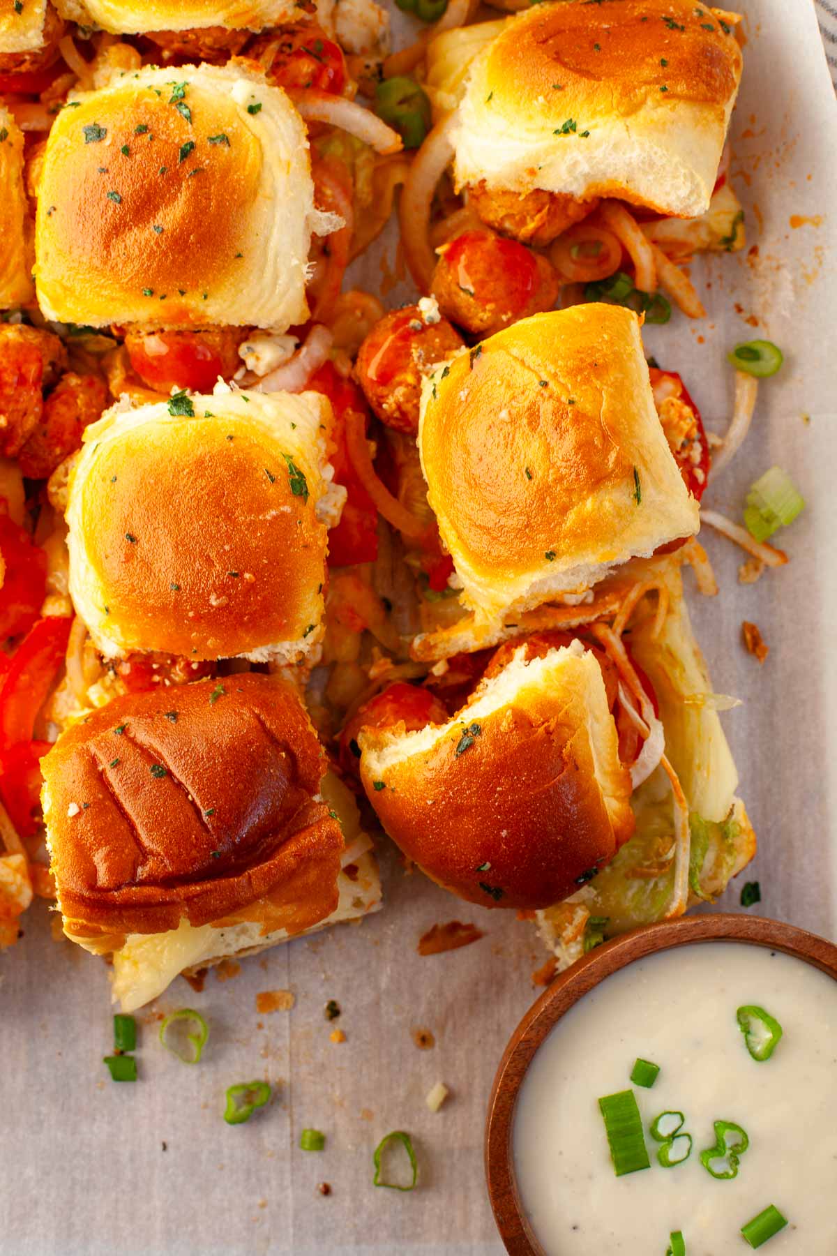 buffalo chicken meatball sliders cut into servings next to blue cheese dressing