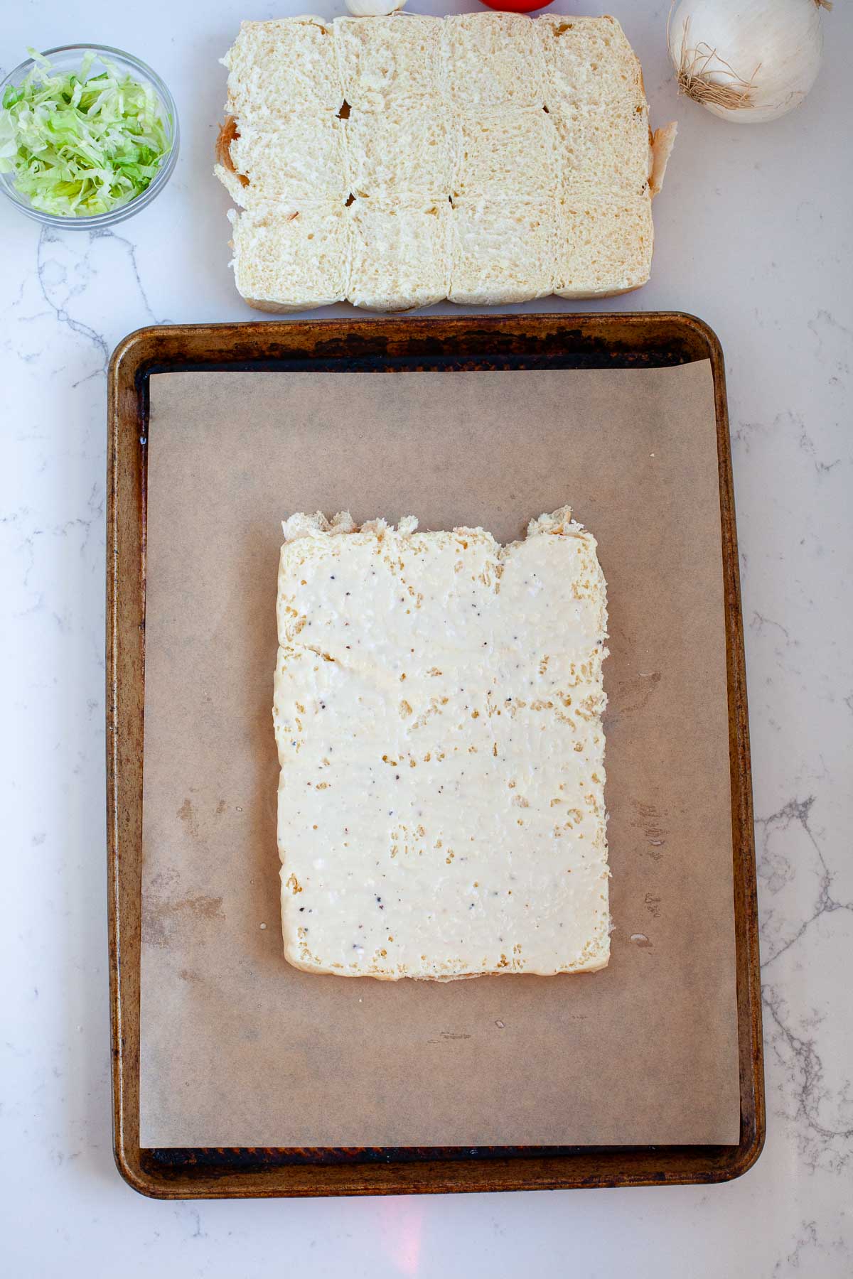 bottom sheet of rolls with blue cheese dressing on parchment paper lined baking sheet