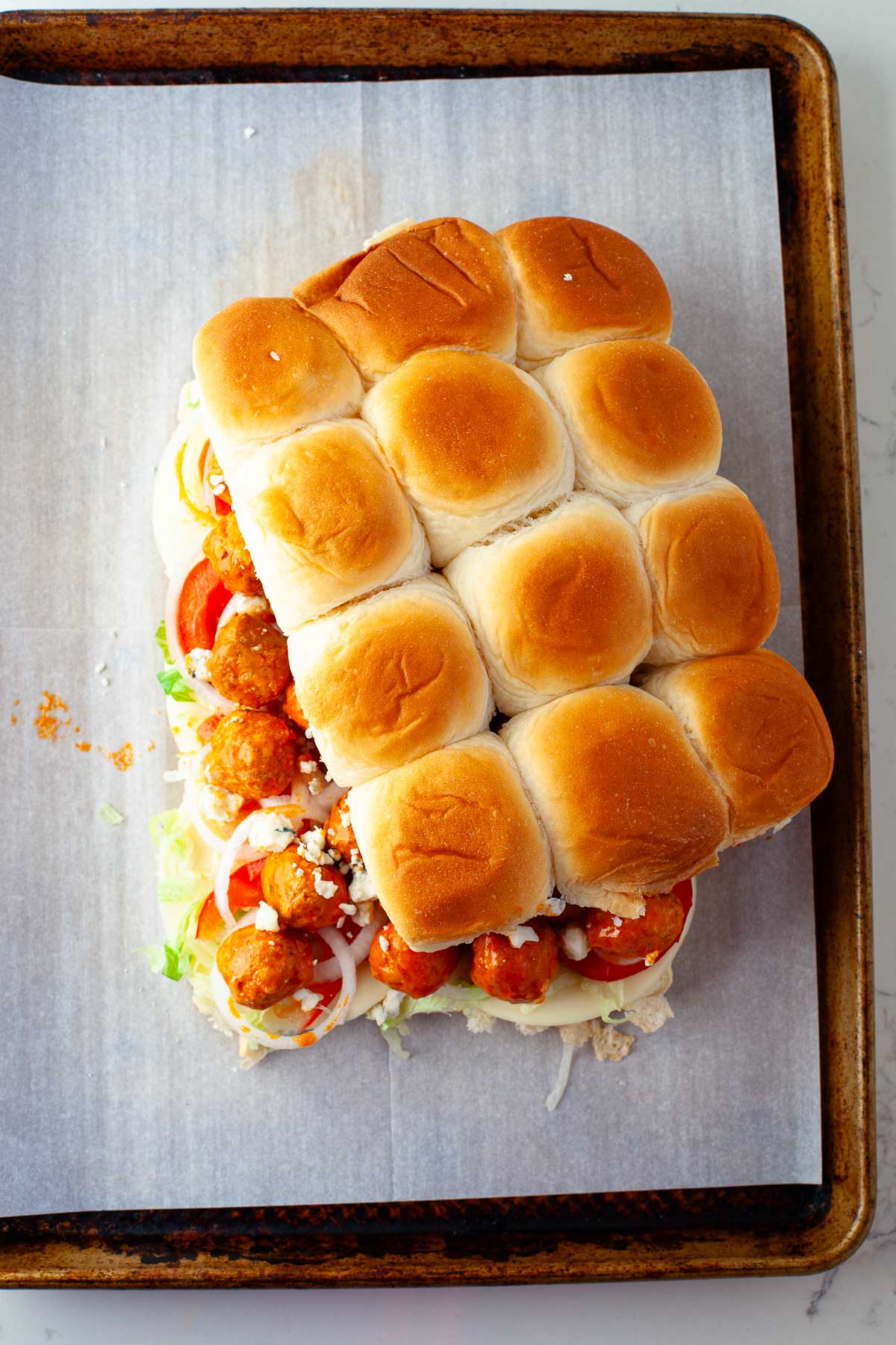 assembled buffalo chicken meatball sliders covered with top sheet of rolls
